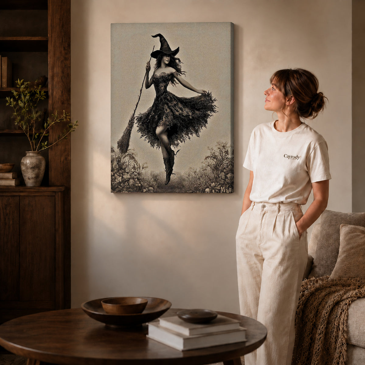 Gallery wrapped dancing witch canvas art with visible canvas edges beside a standing woman.