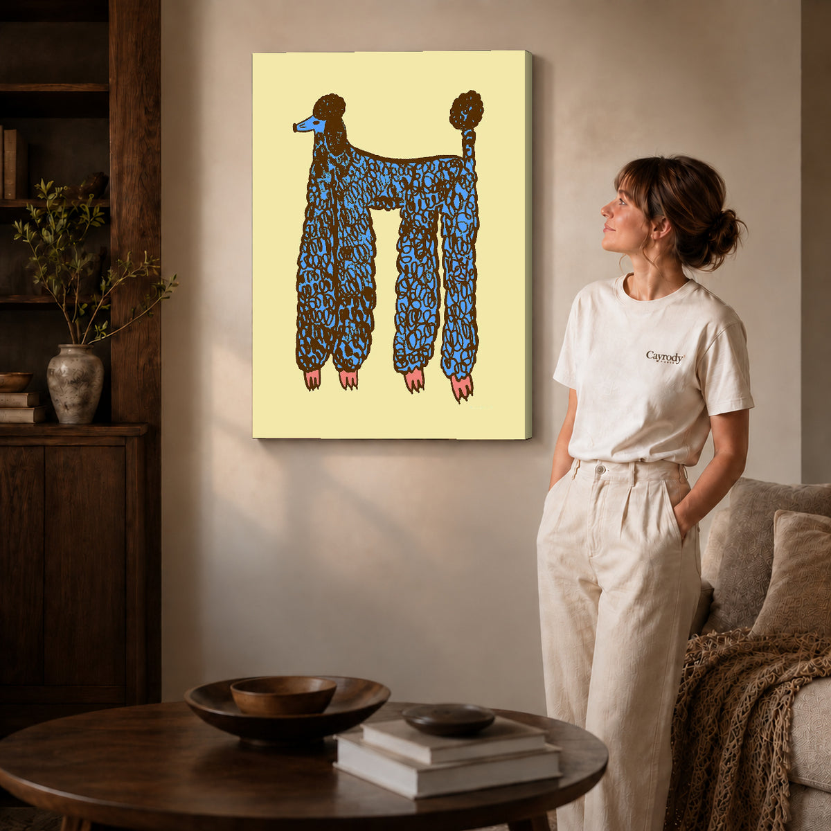 Gallery wrapped blue poodle canvas art with visible canvas edges beside a standing woman.