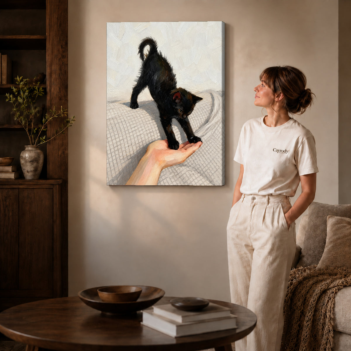 Gallery wrapped black kitten canvas art showing dimensional edges and soft shadows in a living room.