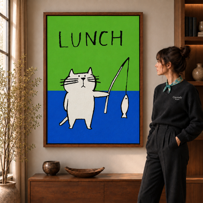Woman in a black sweater viewing a framed white cat fishing LUNCH artwork in a warm living room.