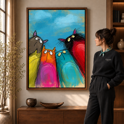 Colorful whimsical cat canvas art with four wide-eyed cats in a walnut frame above a wooden console