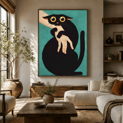 Funny black cat biting hand canvas print displayed in a warm neutral living room above a white sofa