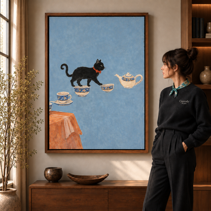 Black cat tea party canvas wall art with blue-and-white teacups beside a woman in a sunlit living room.