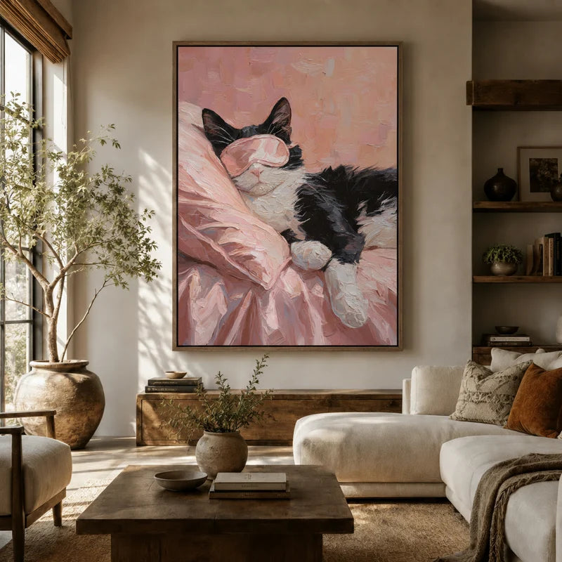 Large framed tuxedo cat canvas above a white sofa in a bright boho living room