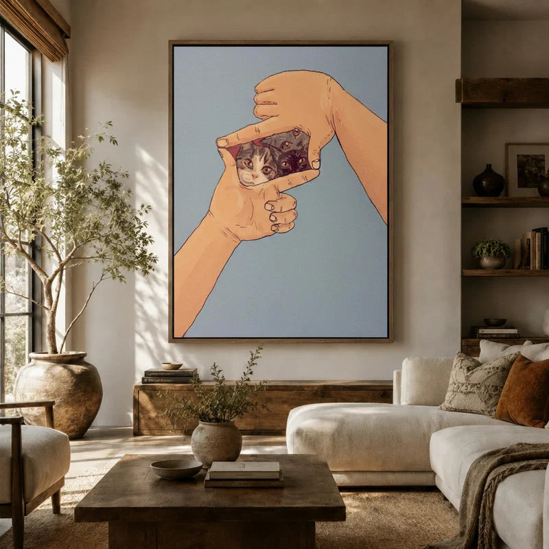 Large cats-in-frame illustration canvas above white sofa in bright boho living room with olive tree