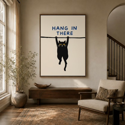 Hang In There cat canvas print displayed in a warm minimalist living room above a wooden console