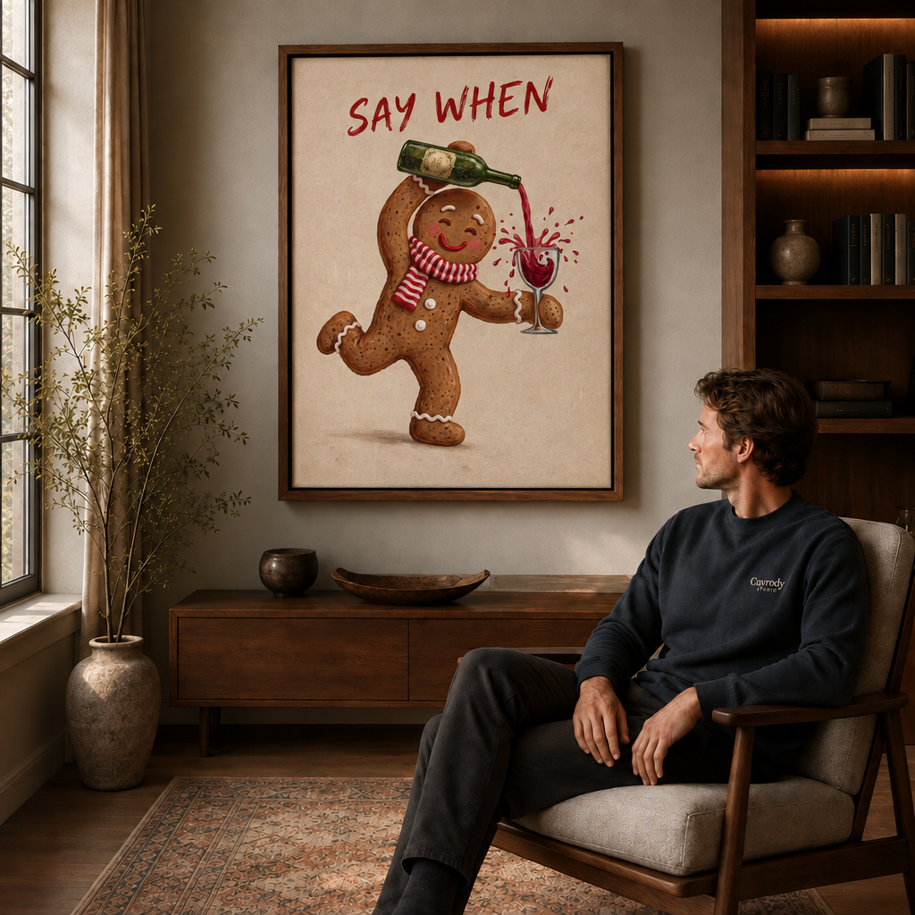 Man seated in an armchair admiring a framed canvas of a gingerbread man pouring wine.