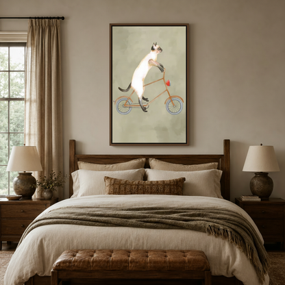 Illustrated Siamese cat bicycle wall art in dark float frame centered above bed in a cozy bedroom