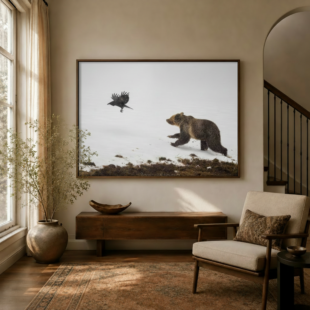 Framed grizzly bear and raven canvas wall art displayed above a wood console in a warm neutral entryway