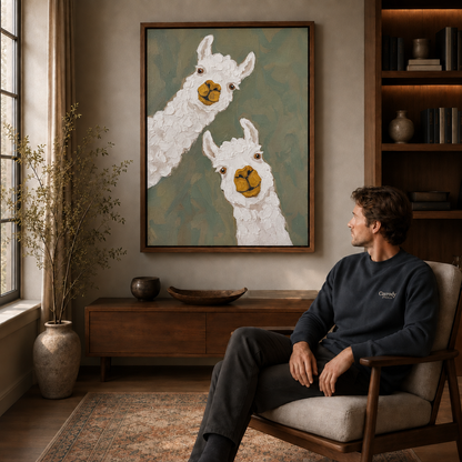 Alpaca canvas wall art above a wood console beside a seated man, armchair, and sunlit living room window.