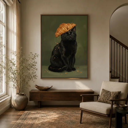 Whimsical black cat with golden croissant hat canvas art displayed in a warm entryway with neutral tones