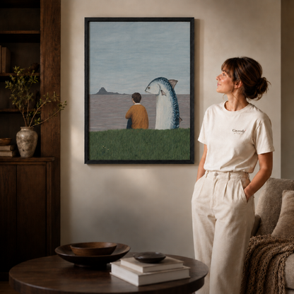 a black-framed surreal canvas of a boy and a giant fish by the sea.