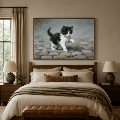 Kitten and flower canvas art hung above a bed in a warm bedroom with linen bedding and wooden headboard
