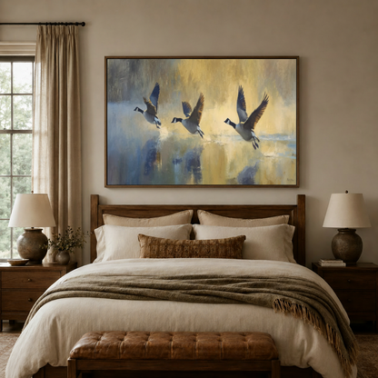 Canada geese taking flight oil painting framed above a bed in a neutral bedroom