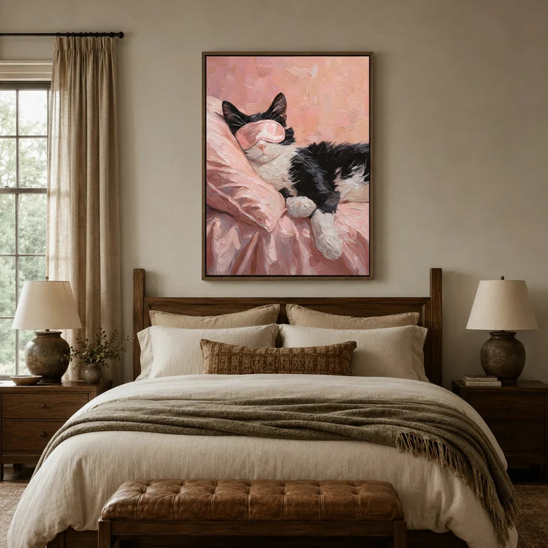 Sleeping cat in pink eye mask framed canvas displayed above a rustic farmhouse bedroom bed