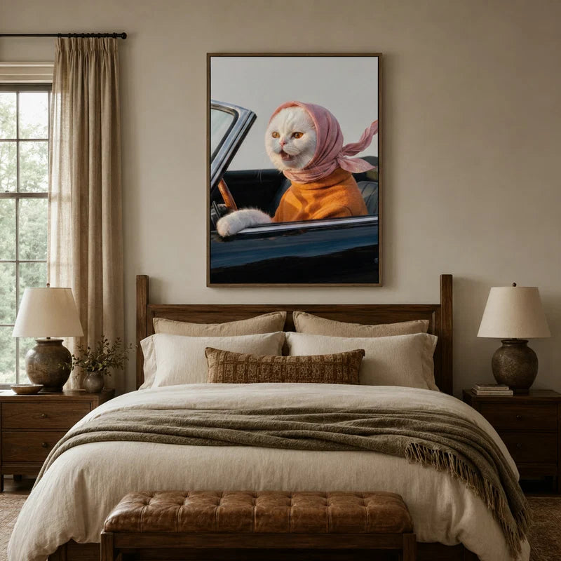 Whimsical white cat driving vintage car canvas art displayed above a bed in a warm farmhouse-style bedroom