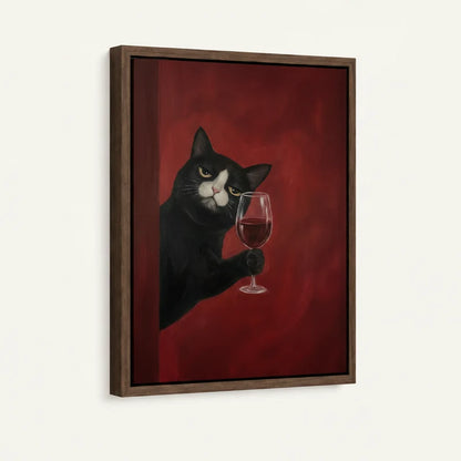 Angled product view of framed canvas — tuxedo cat extending paw with red wine glass on deep crimson in walnut float frame