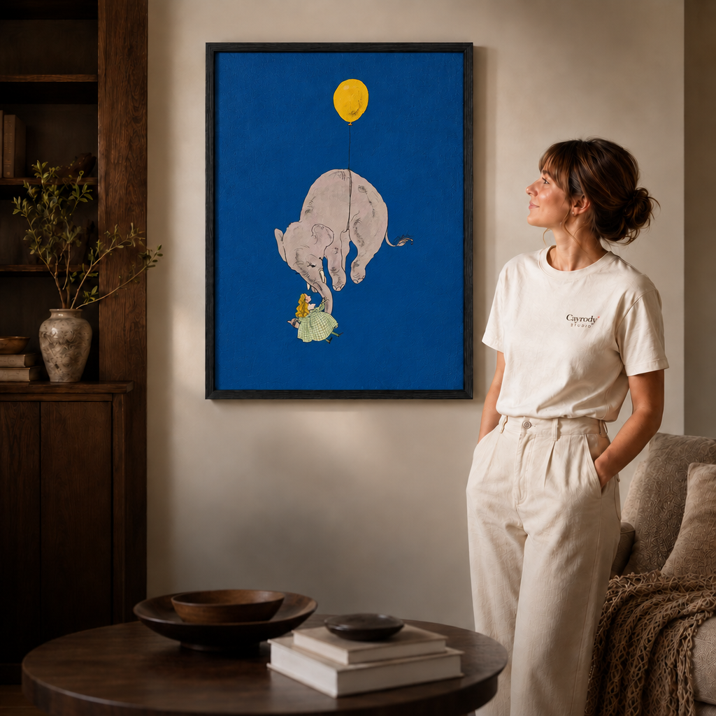 Black-framed whimsical elephant canvas wall art beside a woman in white and a round living room table.