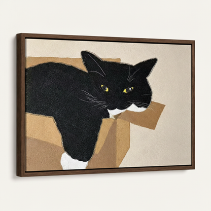 Framed canvas print of black and white cat in cardboard box, dark walnut float frame, 45-degree view