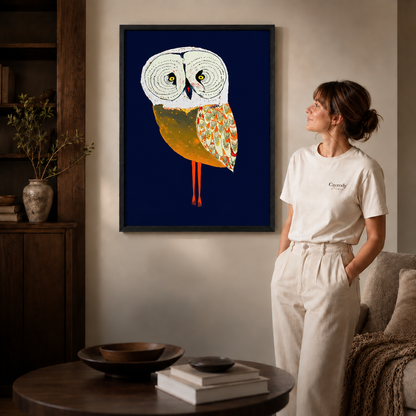 Owl canvas wall art in a black frame beside a woman dressed in white