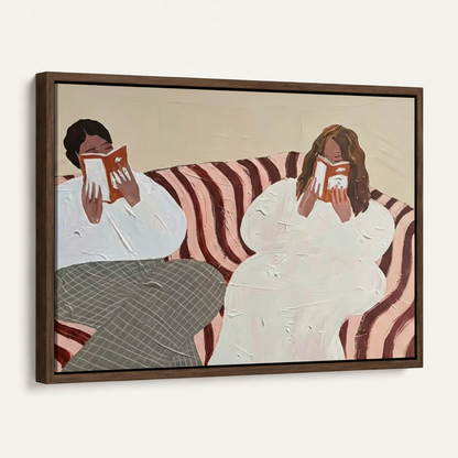 Framed two women reading canvas print in dark walnut float frame, angled product view on white background