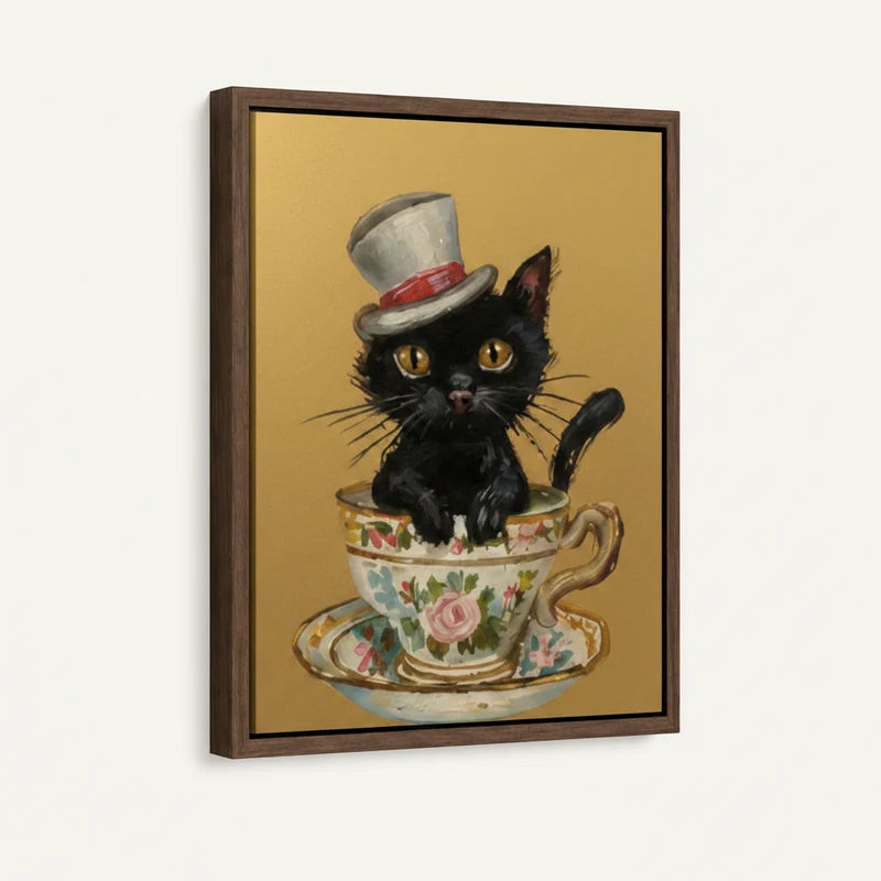 Side-angle view of framed canvas showing black kitten in white top hat sitting in a floral Victorian teacup