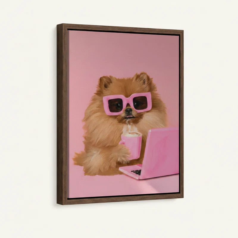 Side-angle view of framed canvas showing fluffy Pomeranian in pink sunglasses holding a pink cup