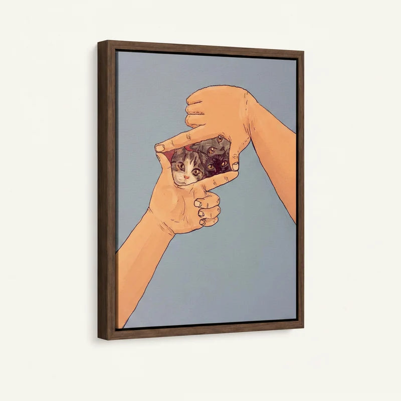 Cats peeking through finger frame canvas in dark walnut floater frame, 3/4 angle view on white background