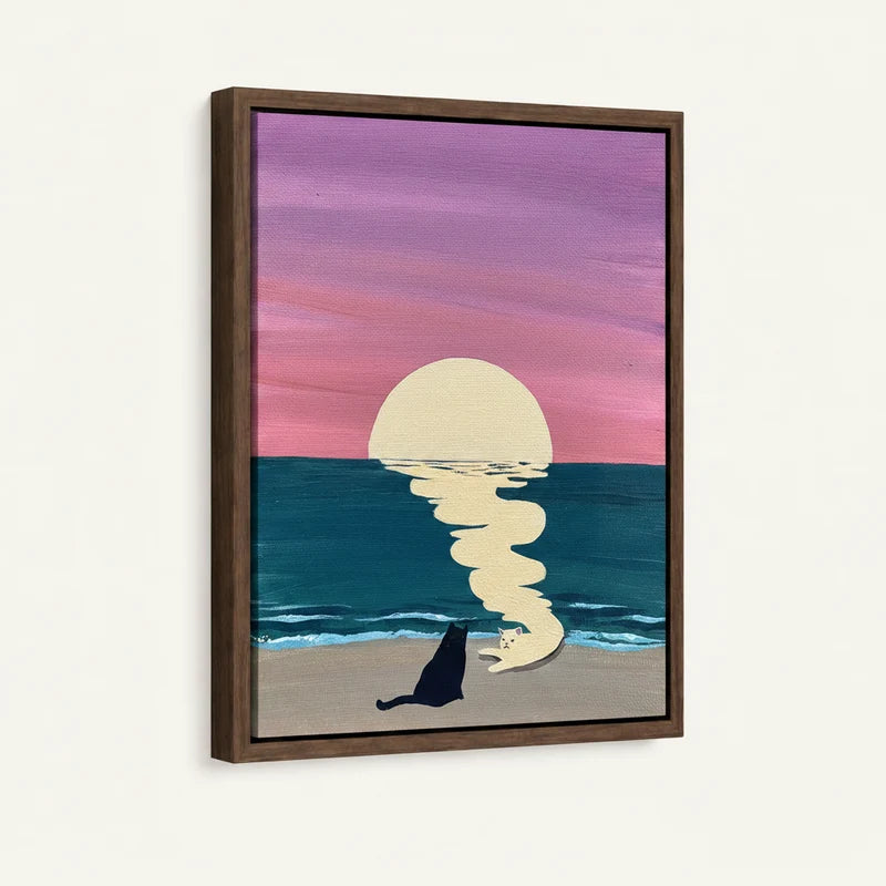 Framed canvas side view of black cat sitting and white cat curled on beach with pink lavender sky and teal ocean