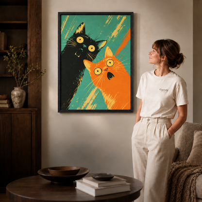 Black-framed pop art cat canvas featuring expressive black and orange cats, displayed as colorful wall decor in a warm interior.