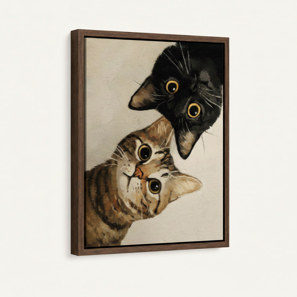 Framed canvas close-up of black cat and tabby cat with wide surprised eyes on cream background