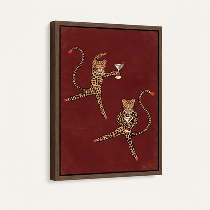 Side-angle view of framed canvas showing two dancing leopards with martinis on a deep burgundy background