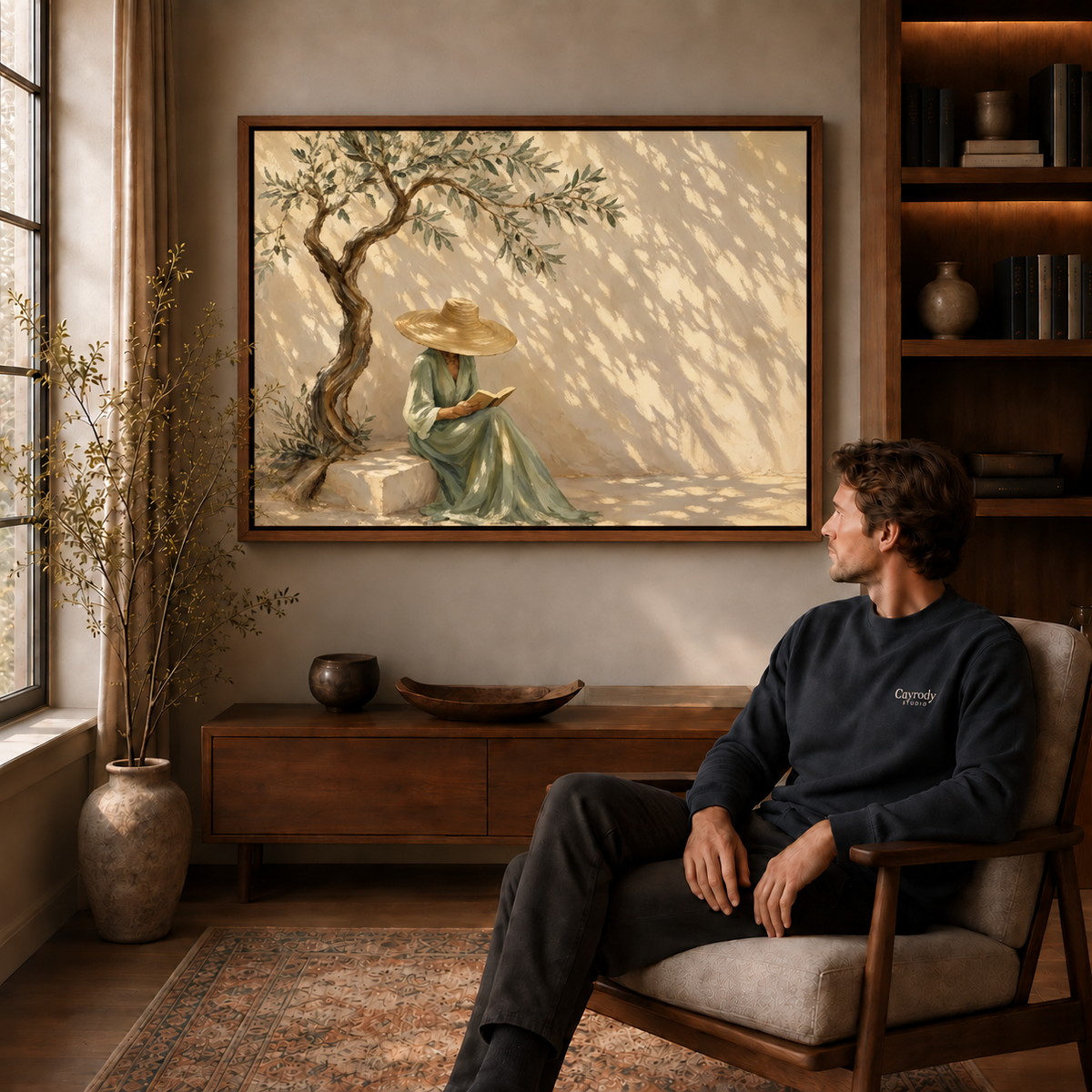 Olive tree reader canvas wall art in a walnut frame above a seated man near a sunlit window.