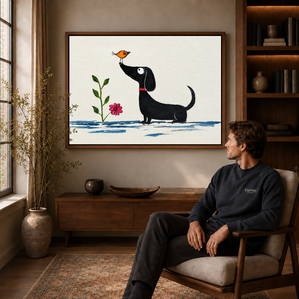 Whimsical dachshund canvas wall art displayed in a walnut frame above a cabinet beside a seated man.