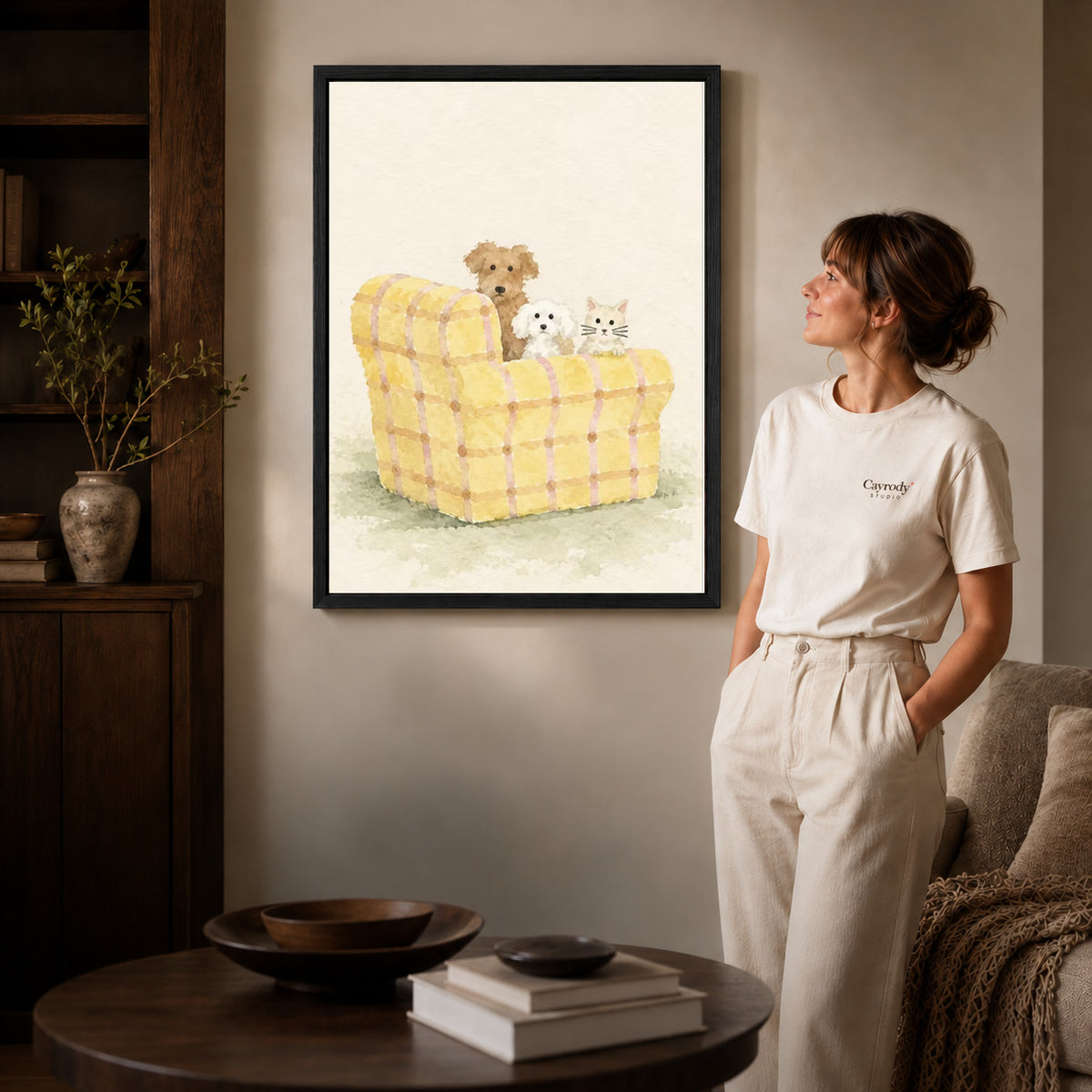 Pet sofa canvas art displayed in a black frame beside a woman, with soft room lighting.
