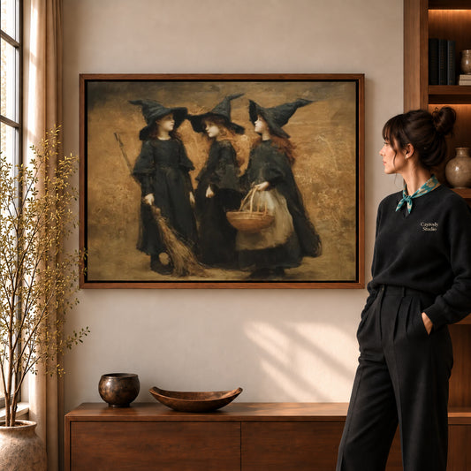 Three witches canvas art in a walnut frame beside a woman in a warmly lit living room.