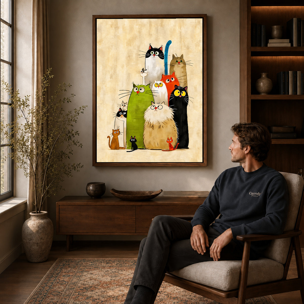 Colorful Cats canvas art above a wooden console beside a seated man in a warm room.