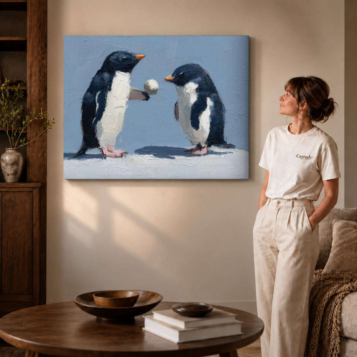 Penguin pair canvas art on gallery wrapped canvas with a visible shaded side edge beside a woman.