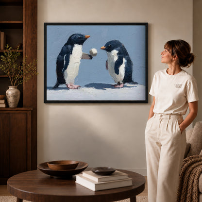 Penguin pair canvas art displayed in a black frame beside a woman, with soft room lighting.
