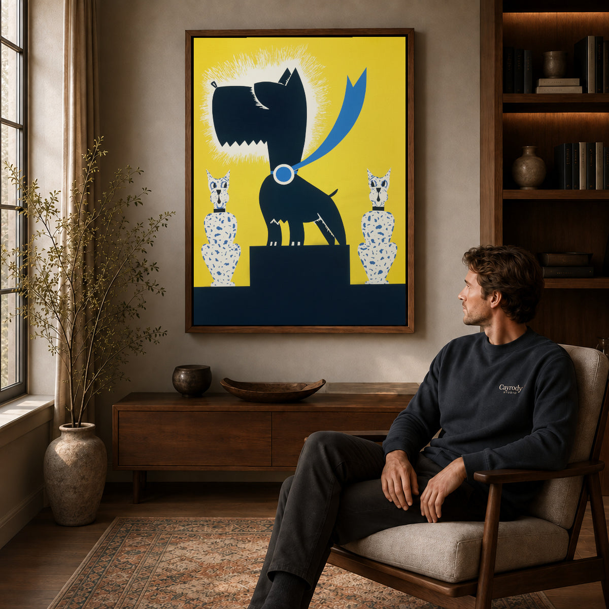 Black terrier canvas art above a wooden console near a seated man and leafy branches.