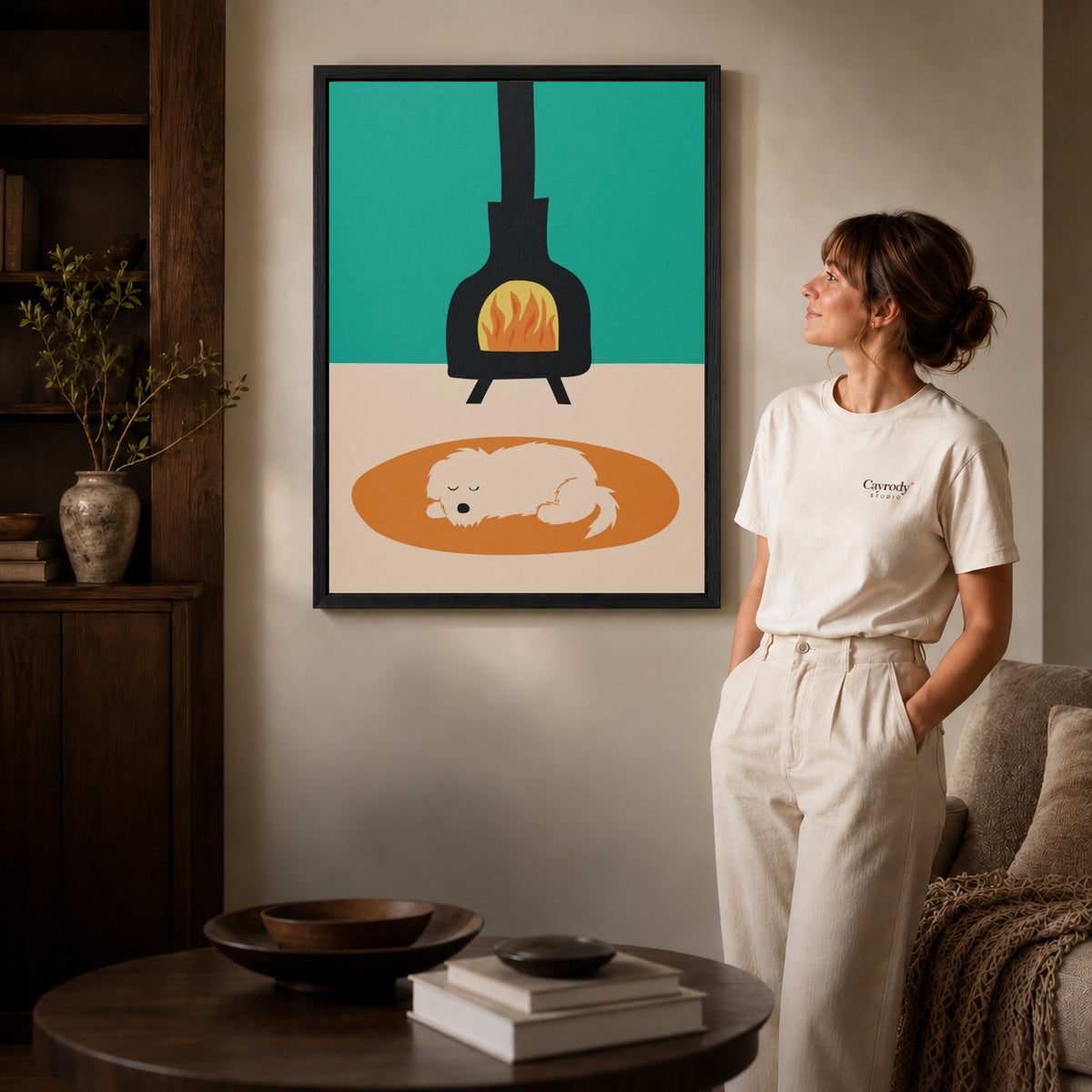 Fireplace dog canvas art displayed in a black frame beside a woman, with soft room lighting.