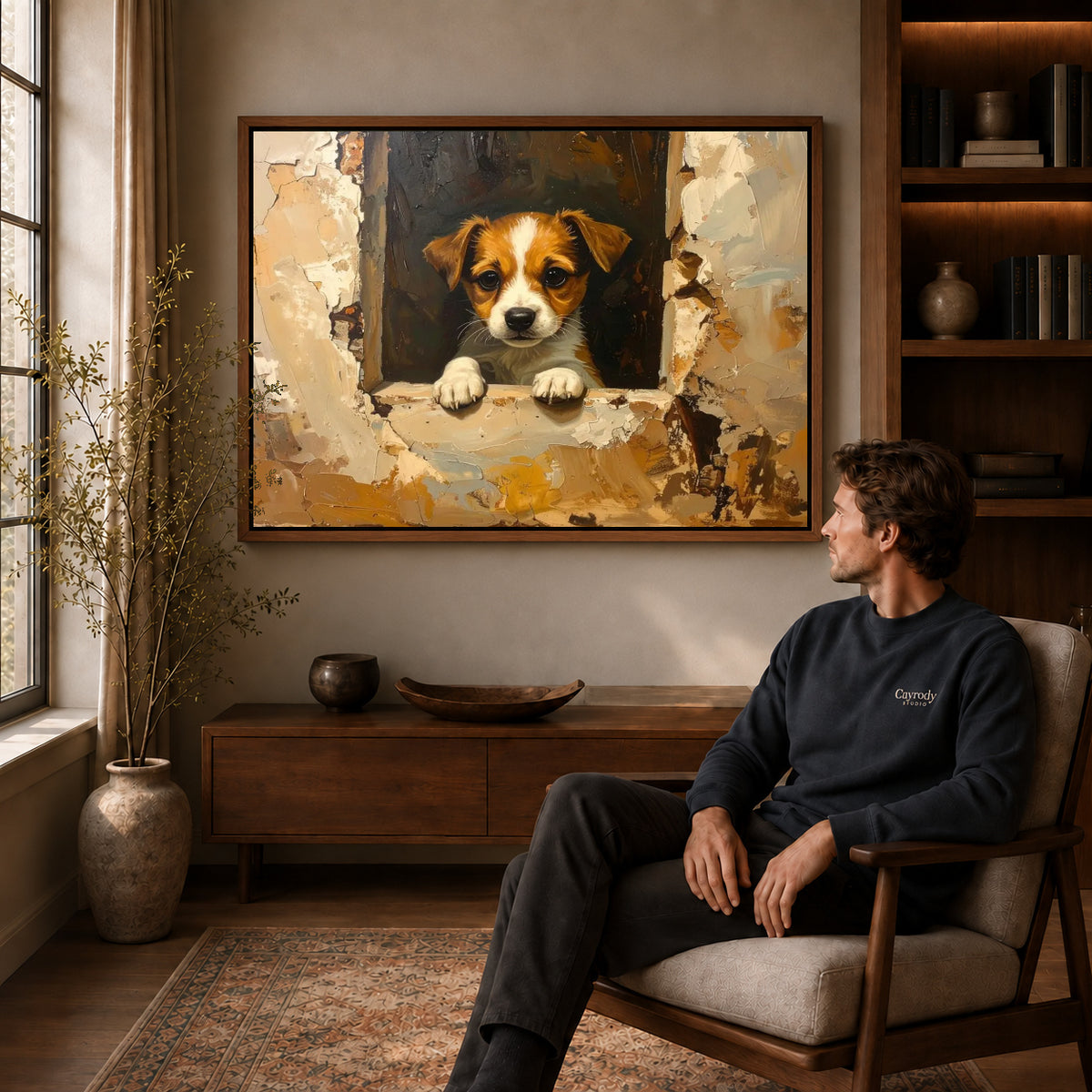 Window puppy canvas art above a wooden console near a seated man and leafy branches.