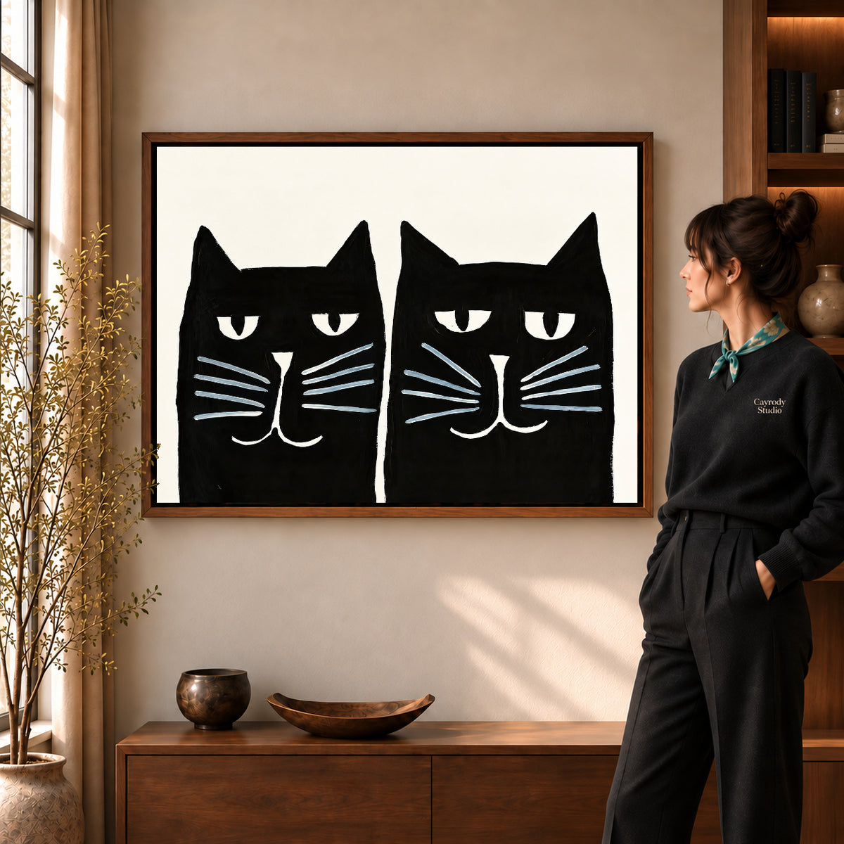 Black cat pair canvas art displayed in a walnut frame against a warm wall near a wooden console.