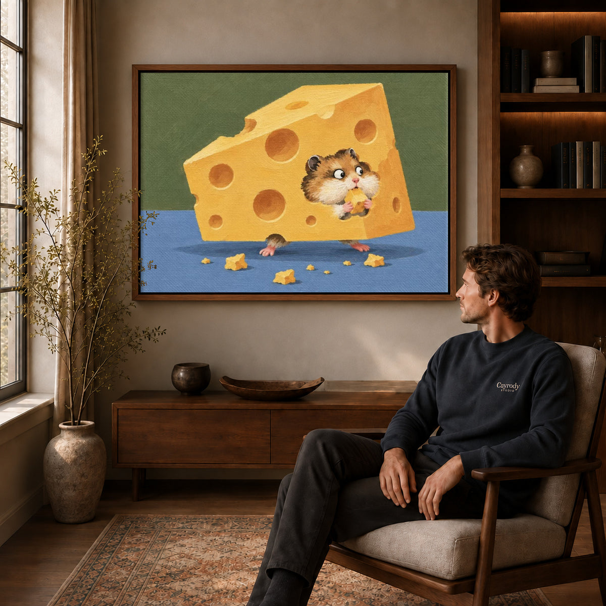 Cheese hamster canvas art above a wooden console near a seated man and leafy branches.