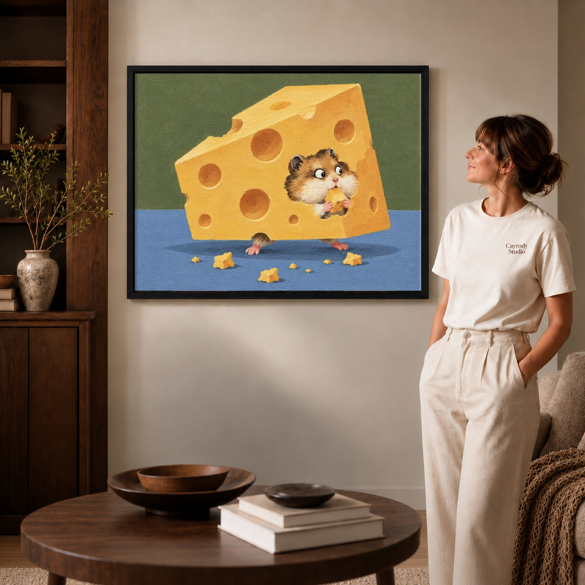 Cheese hamster canvas art displayed in a black frame beside a woman, with soft room lighting.
