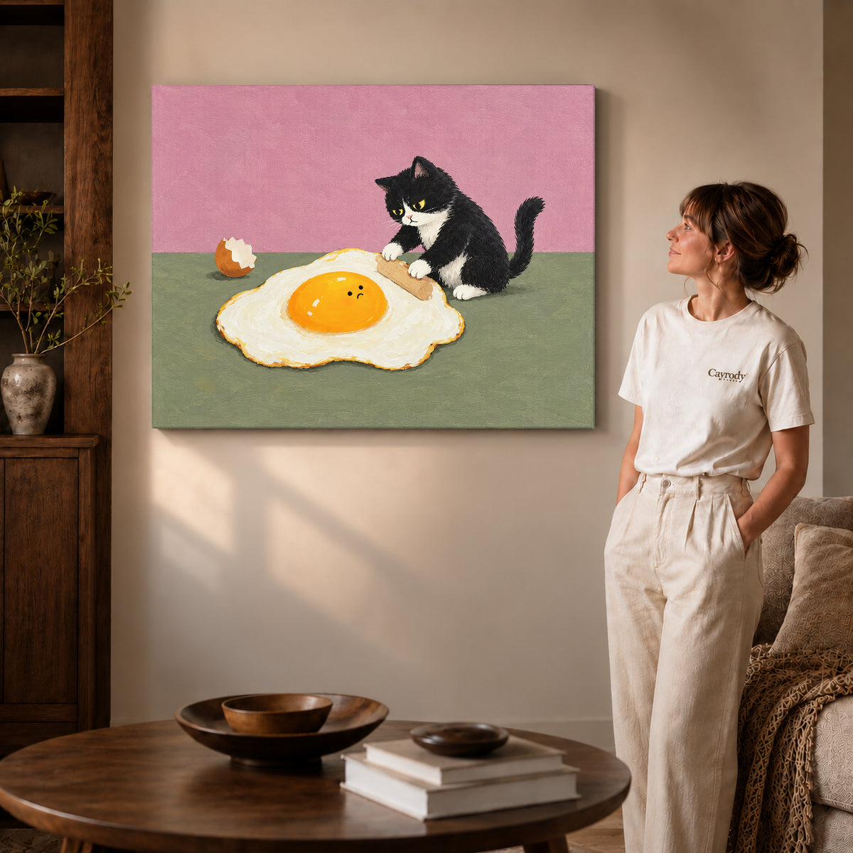 playful egg rolling cat canvas art on gallery-wrapped canvas with visible edge depth beside a standing woman.