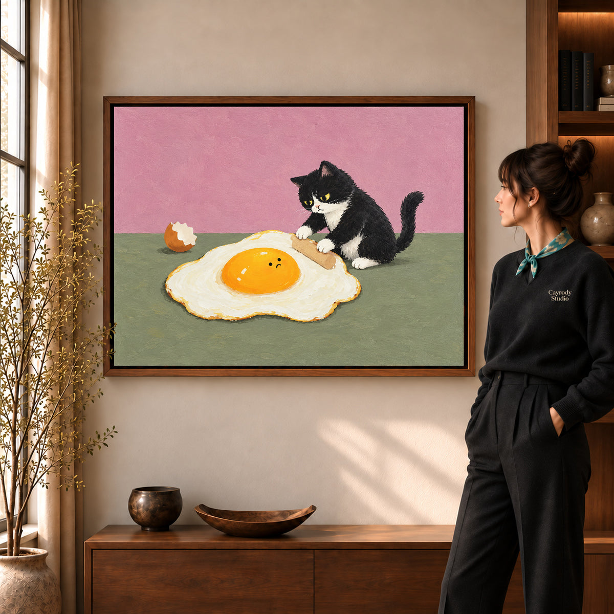 playful egg rolling cat canvas art shown in the walnut frame option within a warm living room.