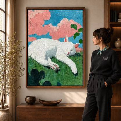 Sleeping cat canvas art in a walnut frame beside a woman in a warmly lit living room.