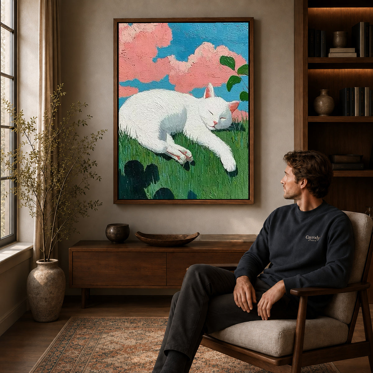 Sleeping cat canvas art above a wooden console near a seated man and leafy branches.