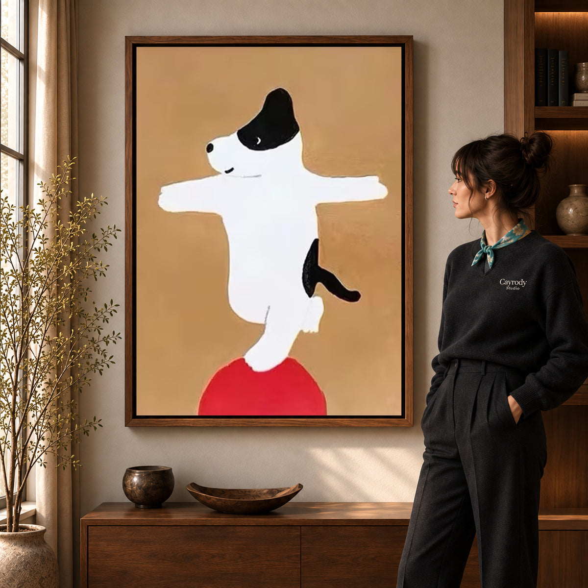 Balancing dog canvas art displayed in a walnut frame against a warm wall near a wooden console.